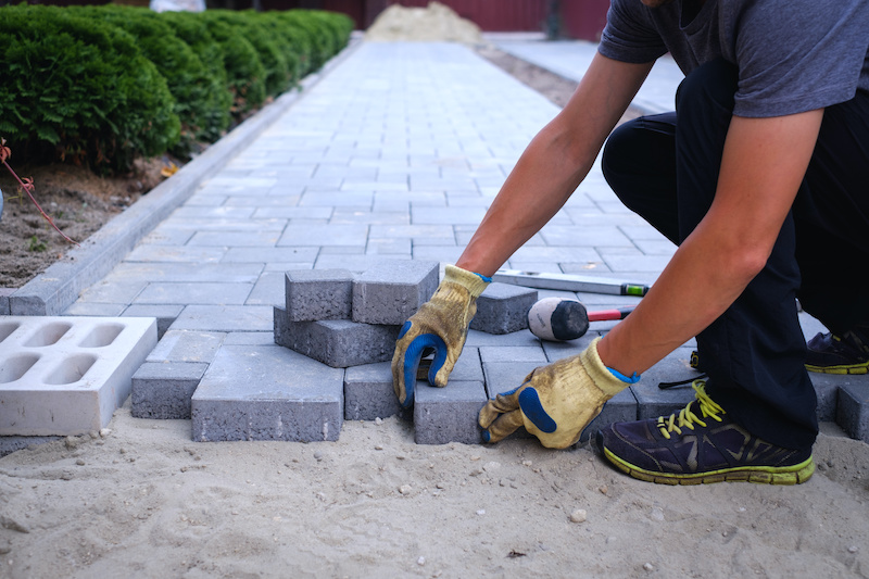 person laying pavers